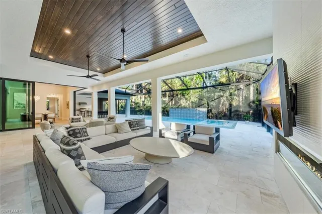 a living room with patio furniture and a flat screen tv