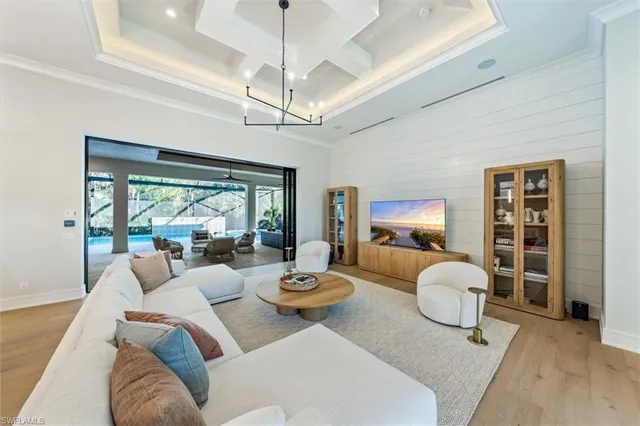 a living room with furniture a chandelier and a large window