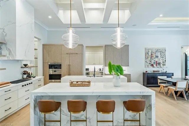 a kitchen with a dining table chairs and refrigerator