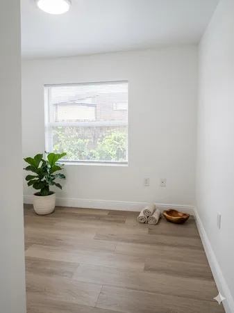 a room with a wooden floor and a window