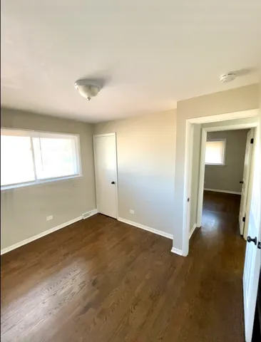 an empty room with a window and wooden floor