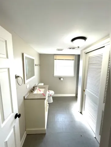 a bathroom with a sink toilet and mirror