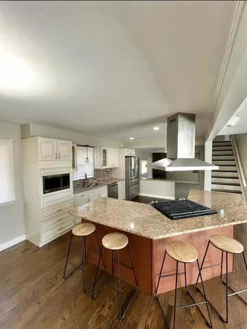 a kitchen with granite countertop white cabinets and chairs