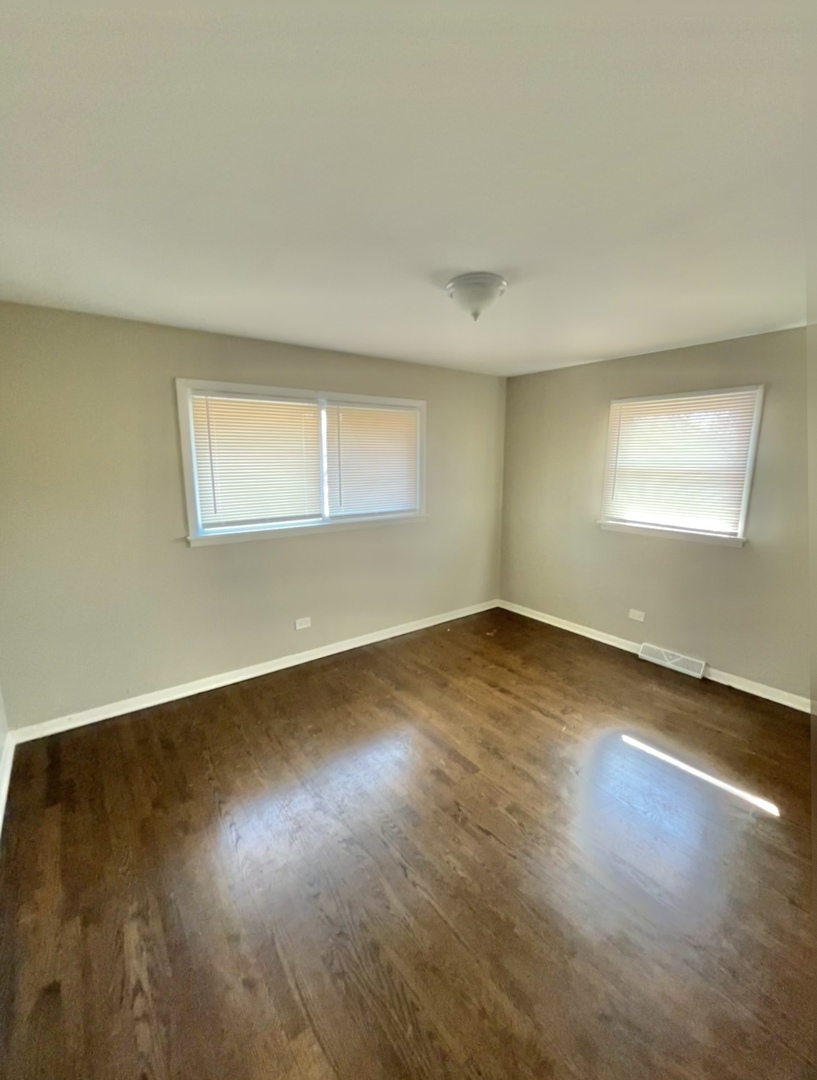 1308 191st Street Homewood, IL 60430 - Photo 8 of 15 an empty room with wooden floor and windows