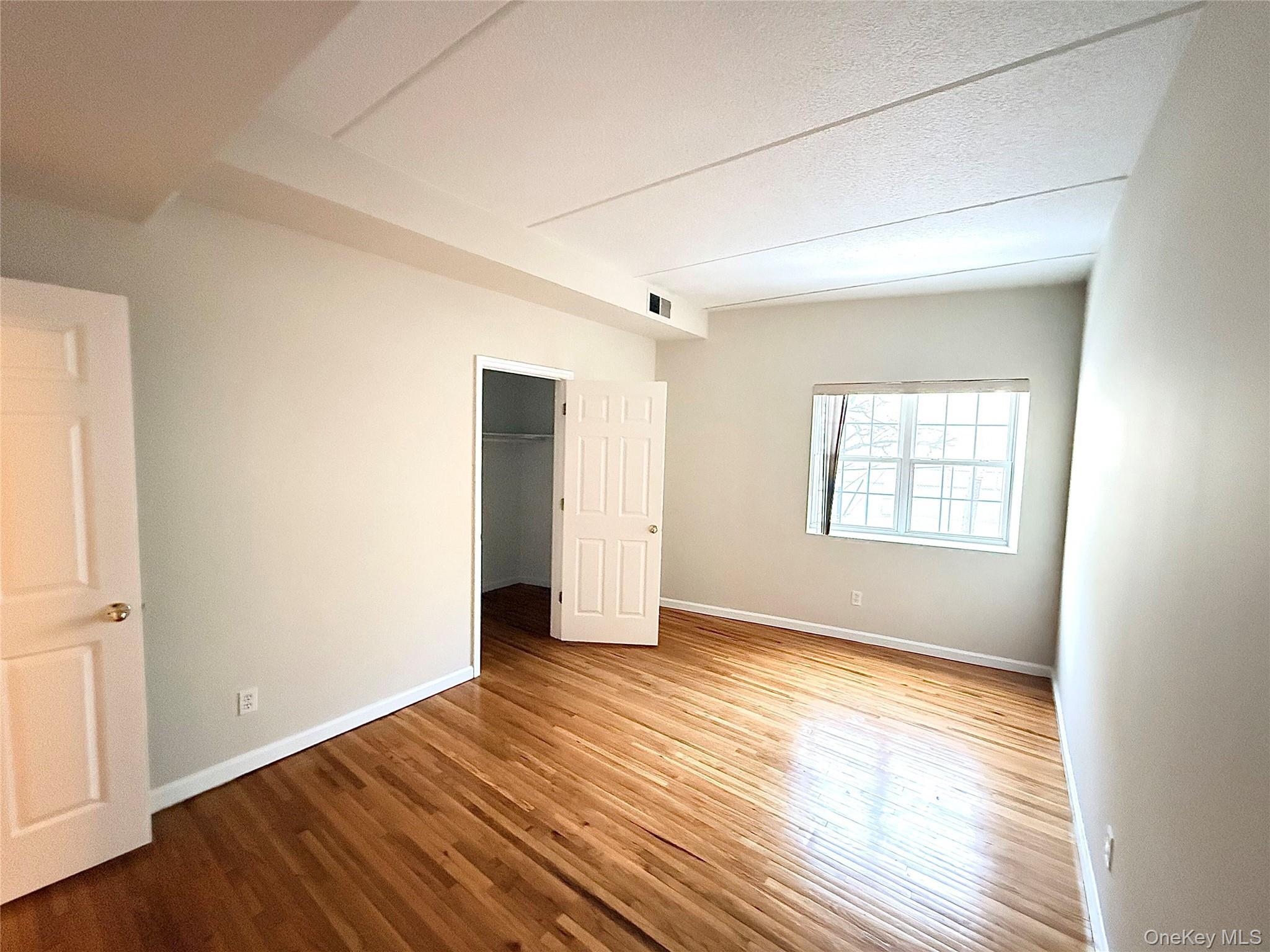 70 Lime Kiln Road, Unit 1A Tuckahoe, NY 10707 - Photo 2 of 10 an empty room with wooden floor and windows