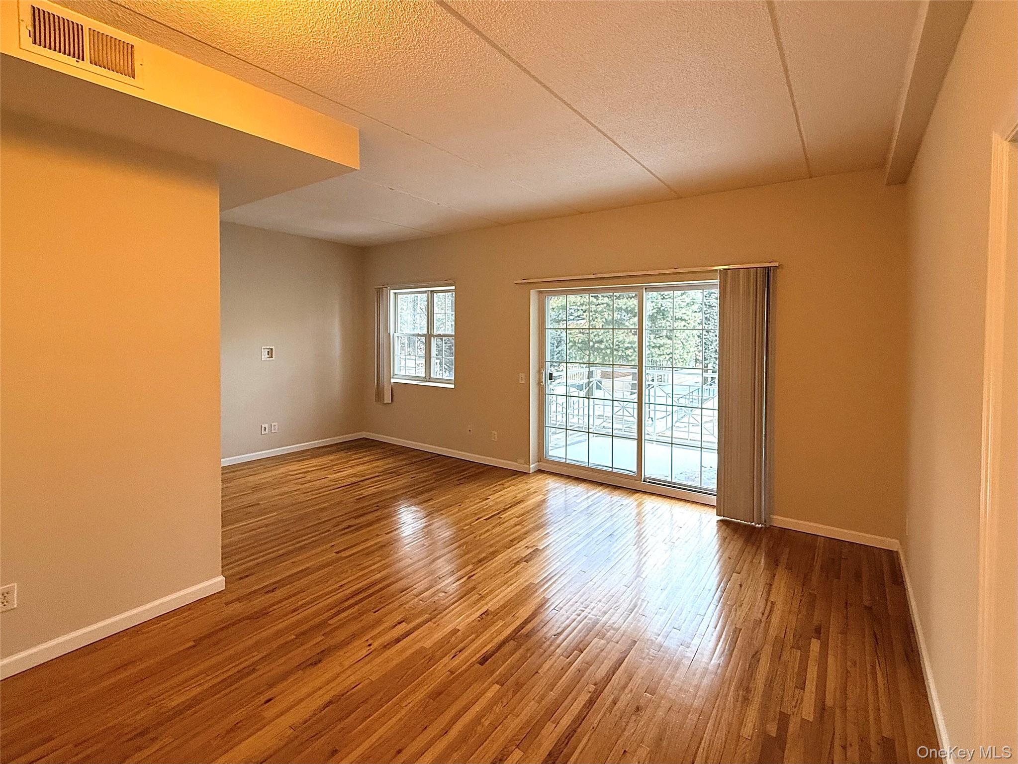 70 Lime Kiln Road, Unit 1A Tuckahoe, NY 10707 - Photo 6 of 10 a view of an empty room with wooden floor and a window