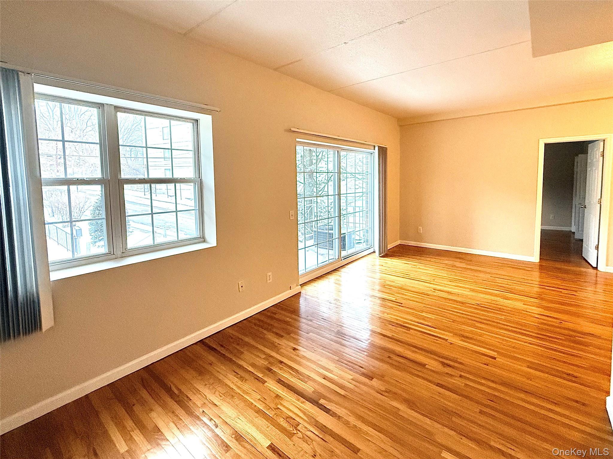 70 Lime Kiln Road, Unit 1A Tuckahoe, NY 10707 - Photo 7 of 10 a view of an empty room with wooden floor and a window