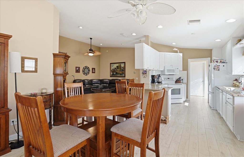 5546 Modena Place Sarasota, FL 34238 - Photo 13 of 67 a dining room with stainless steel appliances kitchen island granite countertop a dining table chairs and a refrigerator
