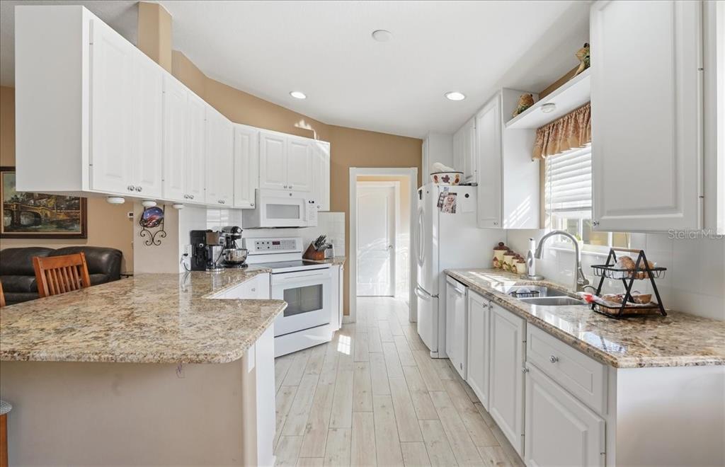 5546 Modena Place Sarasota, FL 34238 - Photo 4 of 67 a kitchen with stainless steel appliances granite countertop a sink refrigerator and cabinets