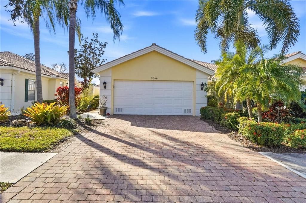 5546 Modena Place Sarasota, FL 34238 - Photo 44 of 67 a view of a house with small yard plants and palm trees