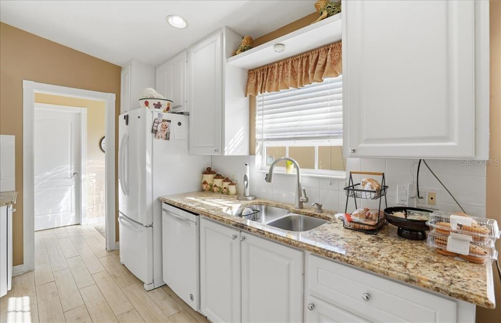 5546 Modena Place Sarasota, FL 34238 - Photo 6 of 67 a kitchen with stainless steel appliances granite countertop a sink and a white wooden cabinets