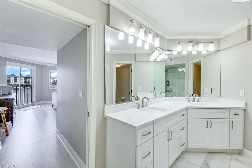 9103 Vanderbilt Drive, Unit 208 Naples, FL 34108 - Photo 11 of 23 a bathroom with a sink vanity and a mirror