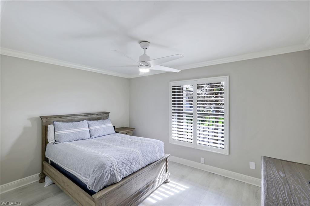 9103 Vanderbilt Drive, Unit 208 Naples, FL 34108 - Photo 12 of 23 a bedroom with a large bed and a window