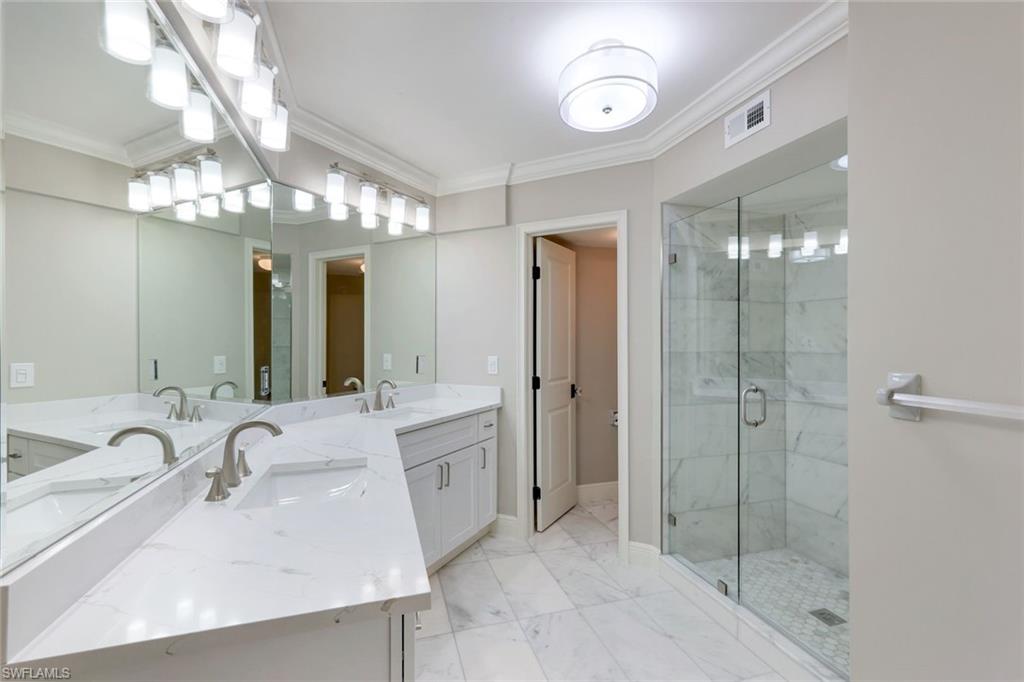 9103 Vanderbilt Drive, Unit 208 Naples, FL 34108 - Photo 14 of 23 a bathroom with a sink double vanity and shower