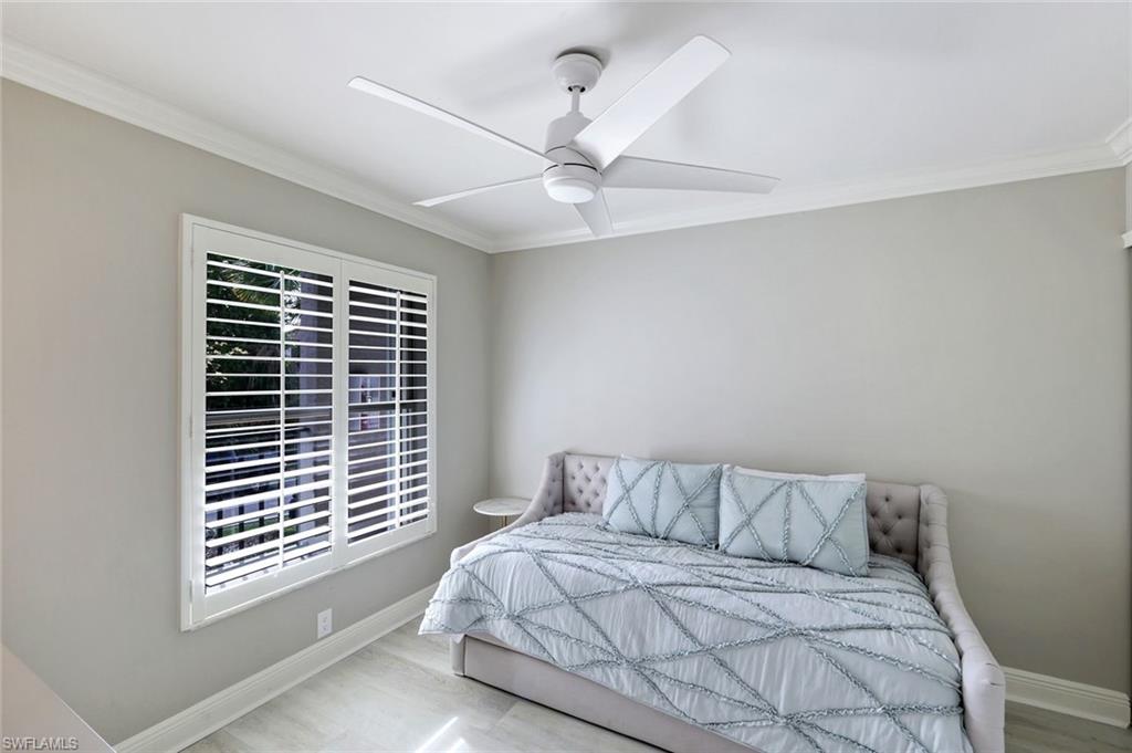 9103 Vanderbilt Drive, Unit 208 Naples, FL 34108 - Photo 15 of 23 a bedroom with a large bed and a window