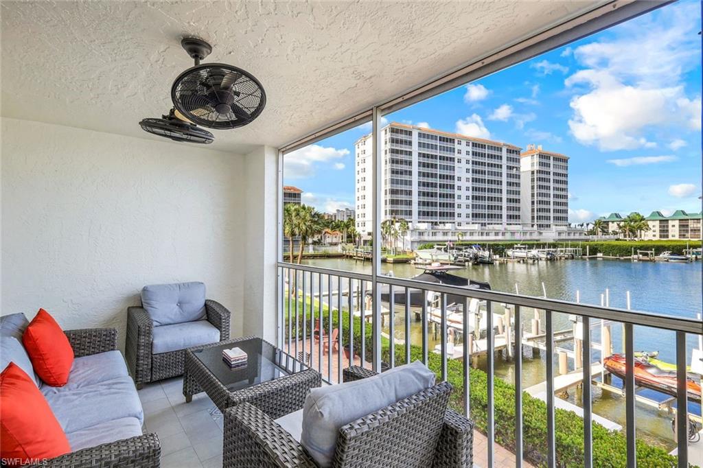 9103 Vanderbilt Drive, Unit 208 Naples, FL 34108 - Photo 16 of 23 a living room with furniture and floor to ceiling window