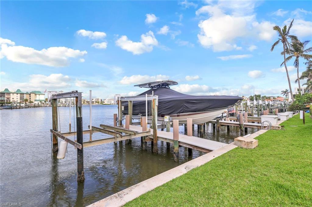 9103 Vanderbilt Drive, Unit 208 Naples, FL 34108 - Photo 19 of 23 a view of a swimming pool with a table and chairs