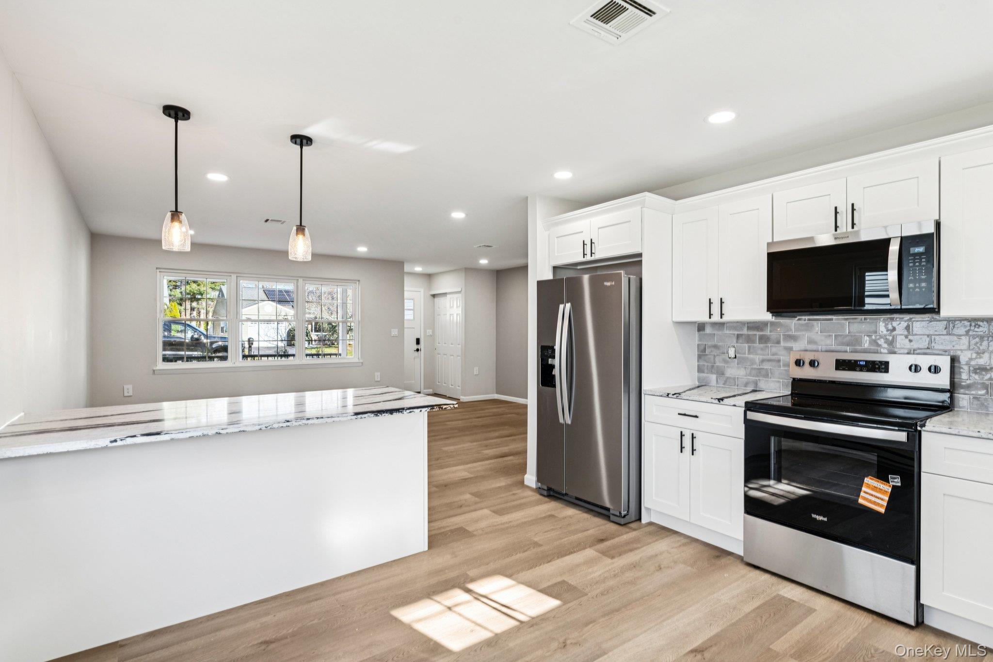 195 Canterbury Drive Ridge, NY 11961 - Photo 11 of 26 a kitchen with stainless steel appliances granite countertop a refrigerator a stove and a sink