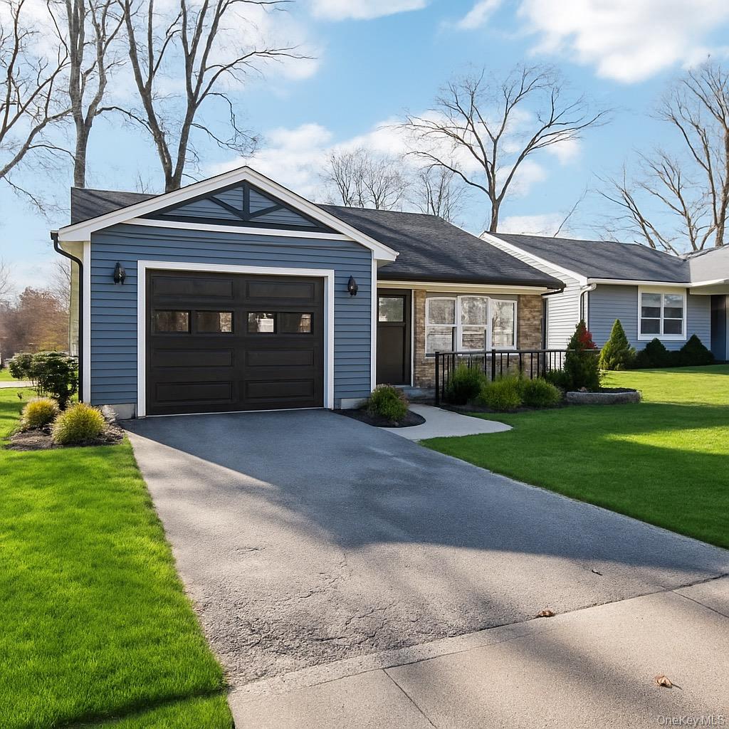 195 Canterbury Drive Ridge, NY 11961 - Photo 2 of 26 a front view of a house with a yard and garage