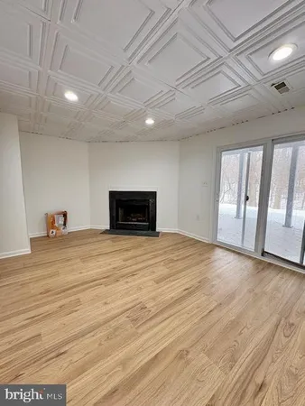 an empty room with wooden floor and fireplace