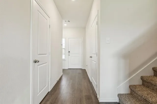 a view of a hallway with wooden floor and staircase