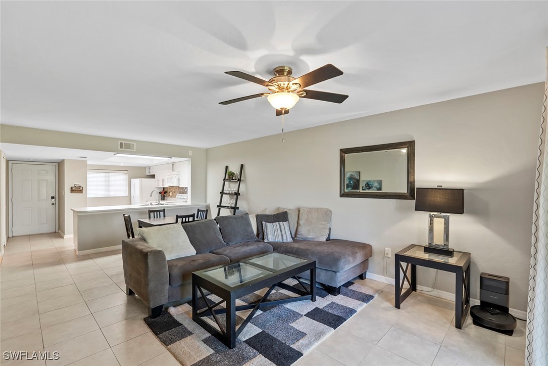 138 Cypress Way East, Unit 404 Naples, FL 34110 - Photo 14 of 32 a living room with furniture a lamp and a window