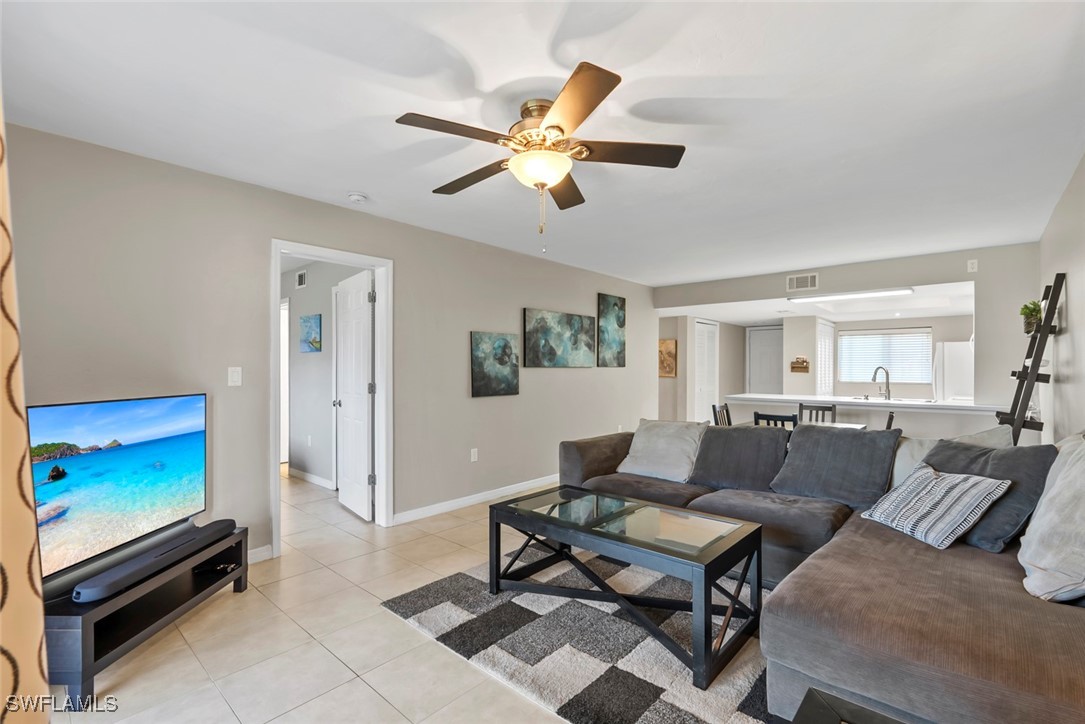 138 Cypress Way East, Unit 404 Naples, FL 34110 - Photo 15 of 32 a living room with furniture a window and a flat screen tv
