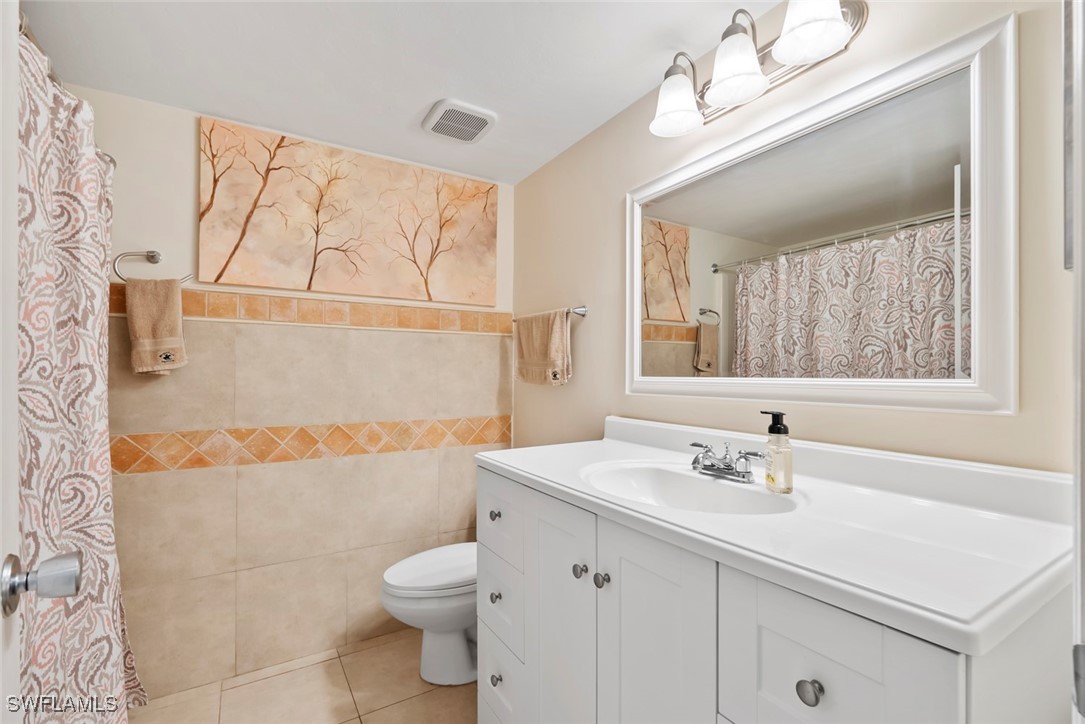 138 Cypress Way East, Unit 404 Naples, FL 34110 - Photo 26 of 32 a bathroom with a sink a toilet and shower