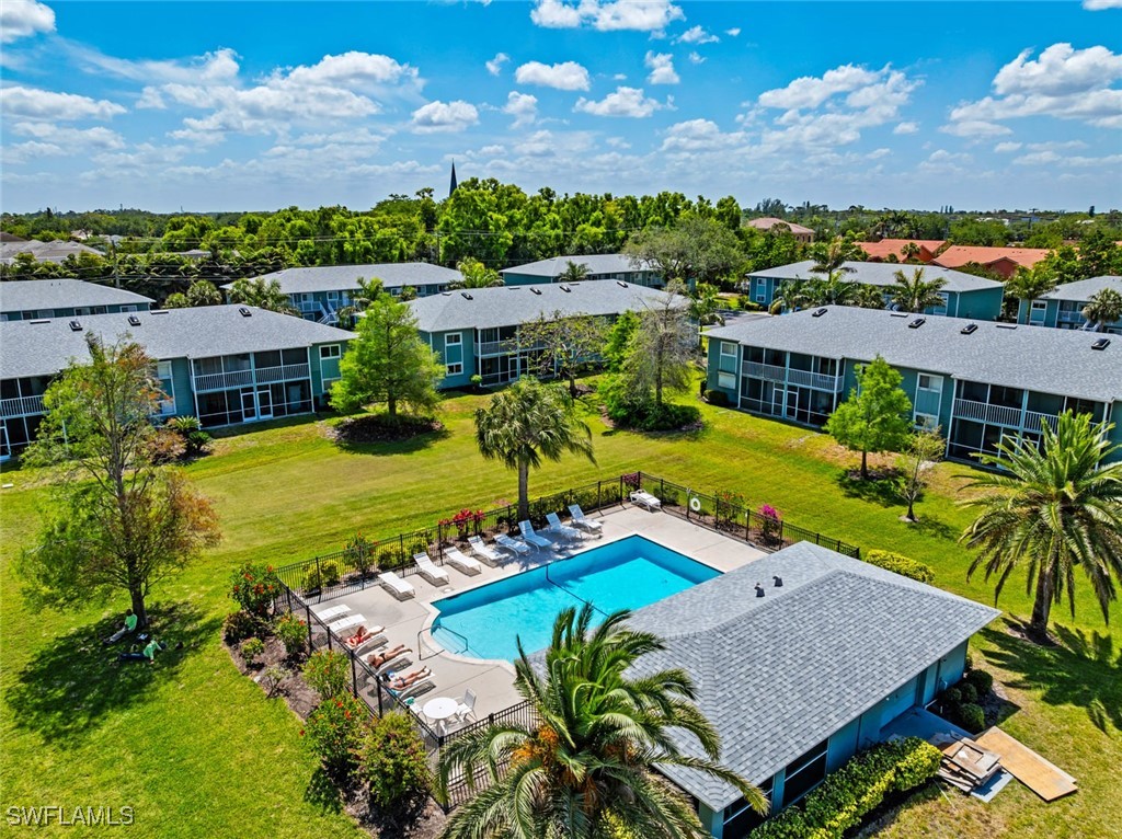 138 Cypress Way East, Unit 404 Naples, FL 34110 - Photo 30 of 32 an aerial view of a house with a swimming pool outdoor seating yard and mountain view
