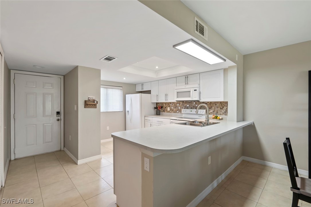 138 Cypress Way East, Unit 404 Naples, FL 34110 - Photo 4 of 32 a kitchen with stainless steel appliances a refrigerator and a stove top oven