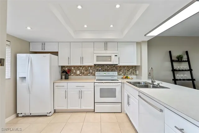 a kitchen with white cabinets and white appliances
