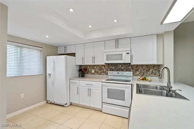a kitchen with white cabinets and white appliances