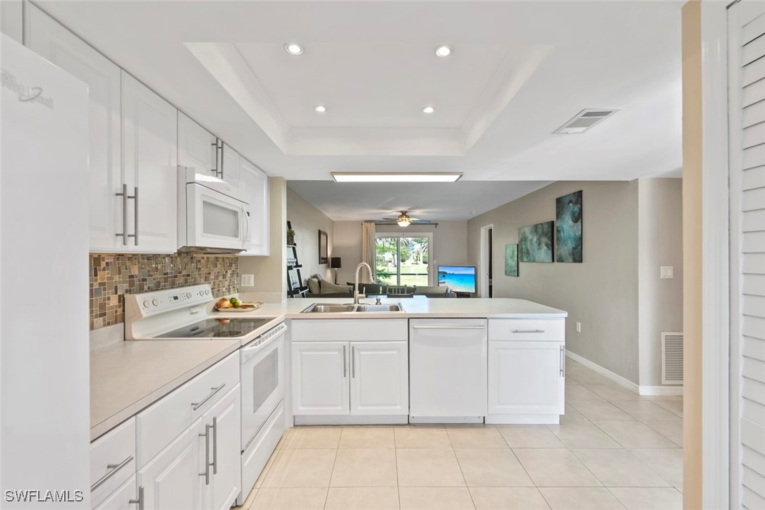 138 Cypress Way East, Unit 404 Naples, FL 34110 - Photo 7 of 32 a kitchen with a sink and cabinets