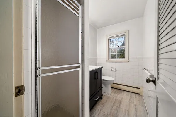 a bathroom with a toilet a sink a mirror a vanity and a window