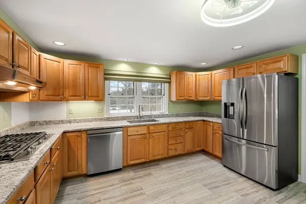 a kitchen with granite countertop cabinets stainless steel appliances a sink and window