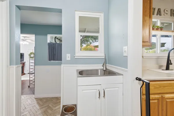 a kitchen with a granite countertop sink and a refrigerator