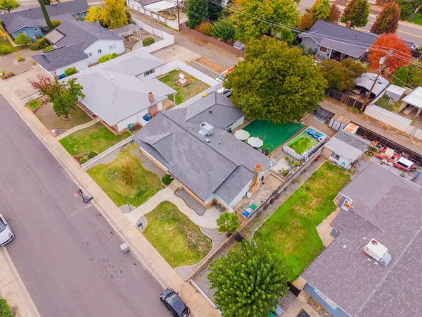 an aerial view of residential house with yard and swimming pool