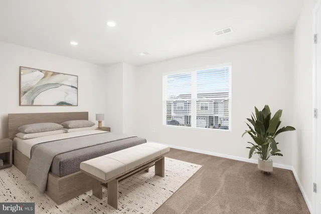 a bedroom with a large bed and a potted plant