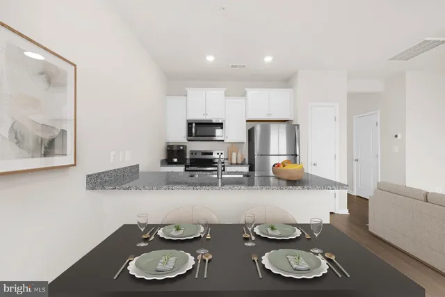 a kitchen with stainless steel appliances granite countertop a sink stove and microwave with wooden floor