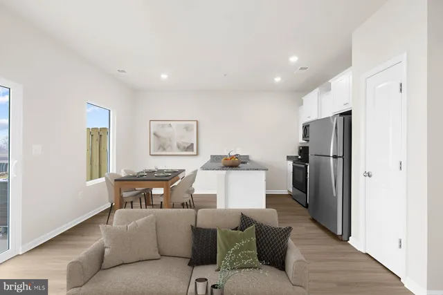 a living room with furniture a refrigerator and a table