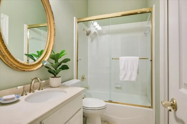 a bathroom with a granite countertop sink a toilet and a mirror