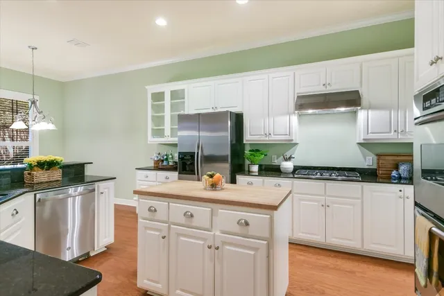 a kitchen with white cabinets and appliances
