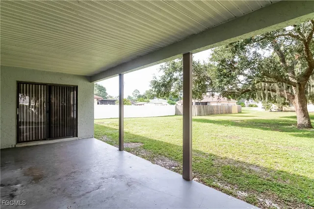 a view of a room with floor to ceiling windows and tree