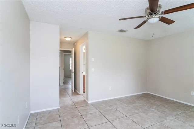 an empty room and chandelier fan
