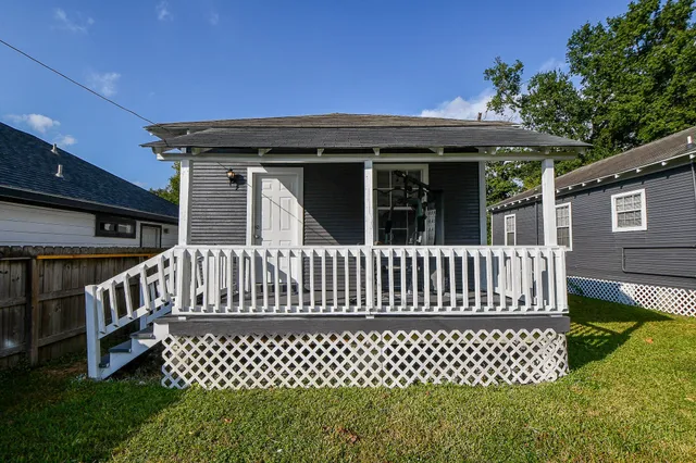 a view of a house with wooden deck and a bench