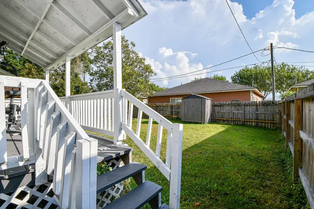 a view of a house with backyard and trees