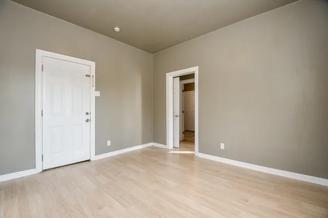 a view of an empty room with wooden floor