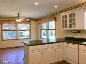 5100 Ellerman Road Zanesville, OH 43701 - Photo 10 of 46 Kitchen with dark countertops, a peninsula, dishwasher, glass insert cabinets, and white cabinets