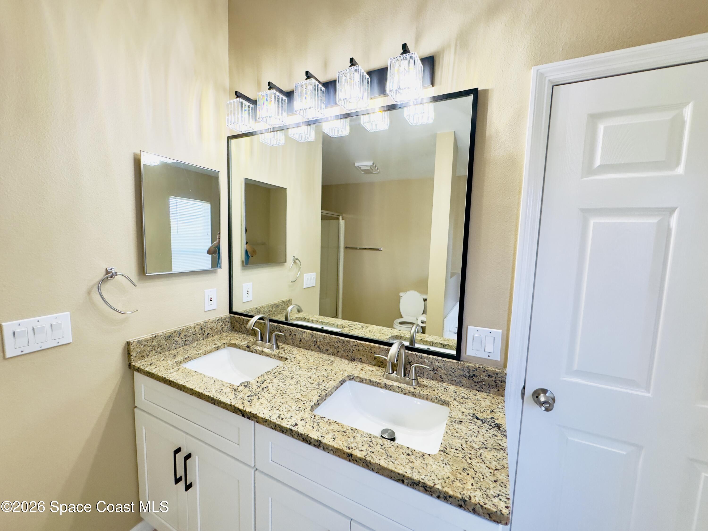 4691 Manchester Drive Rockledge, FL 32955 - Photo 3 of 4 a bathroom with a granite countertop sink vanity and mirror