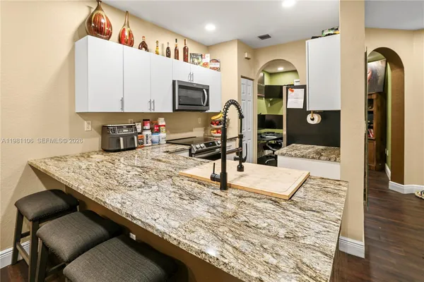 a kitchen with stainless steel appliances kitchen island granite countertop a sink and cabinets
